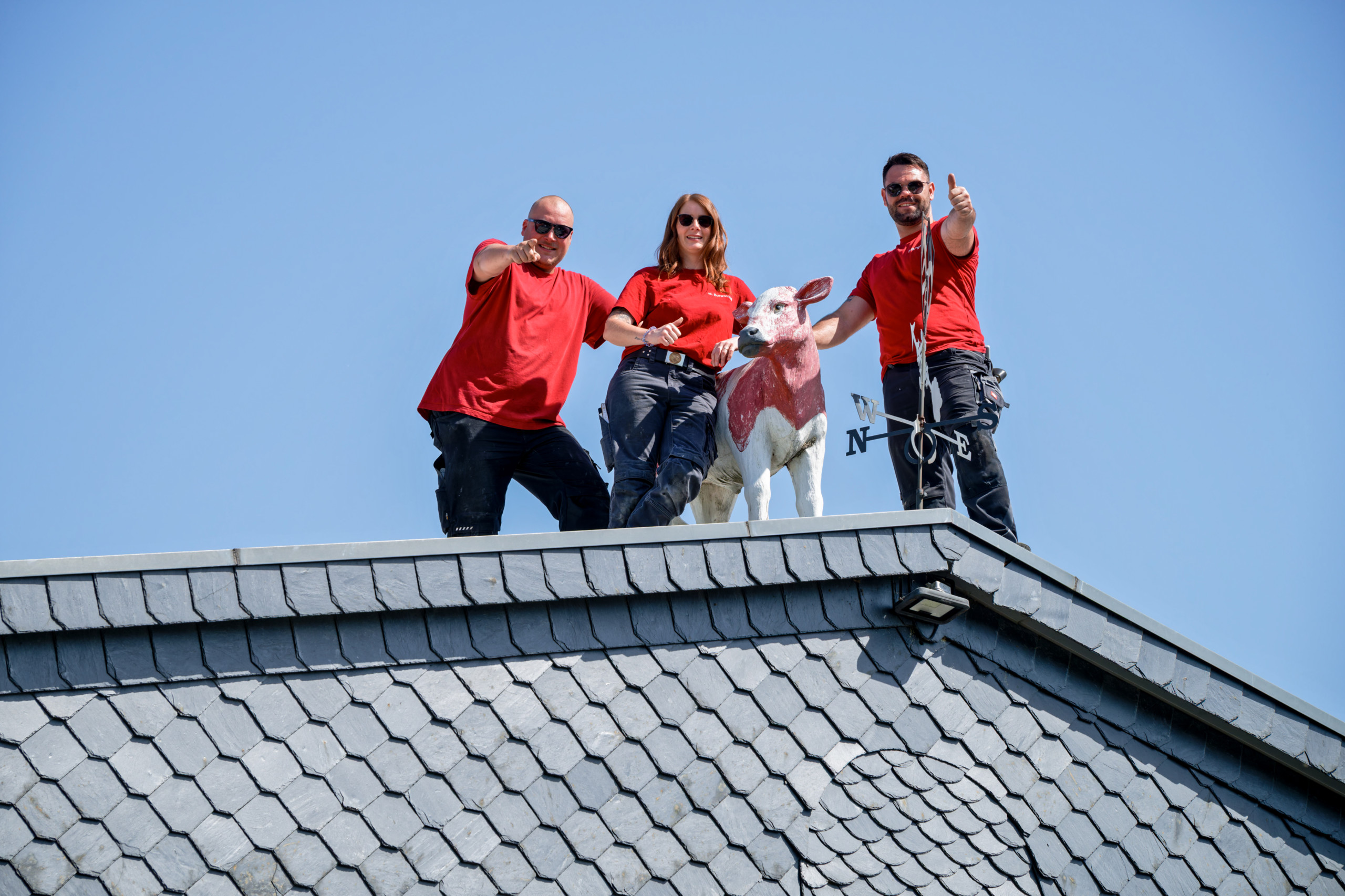 Dachdecker bei Burgwinkel Bedachungen während der Arbeit hoch oben auf dem Dach