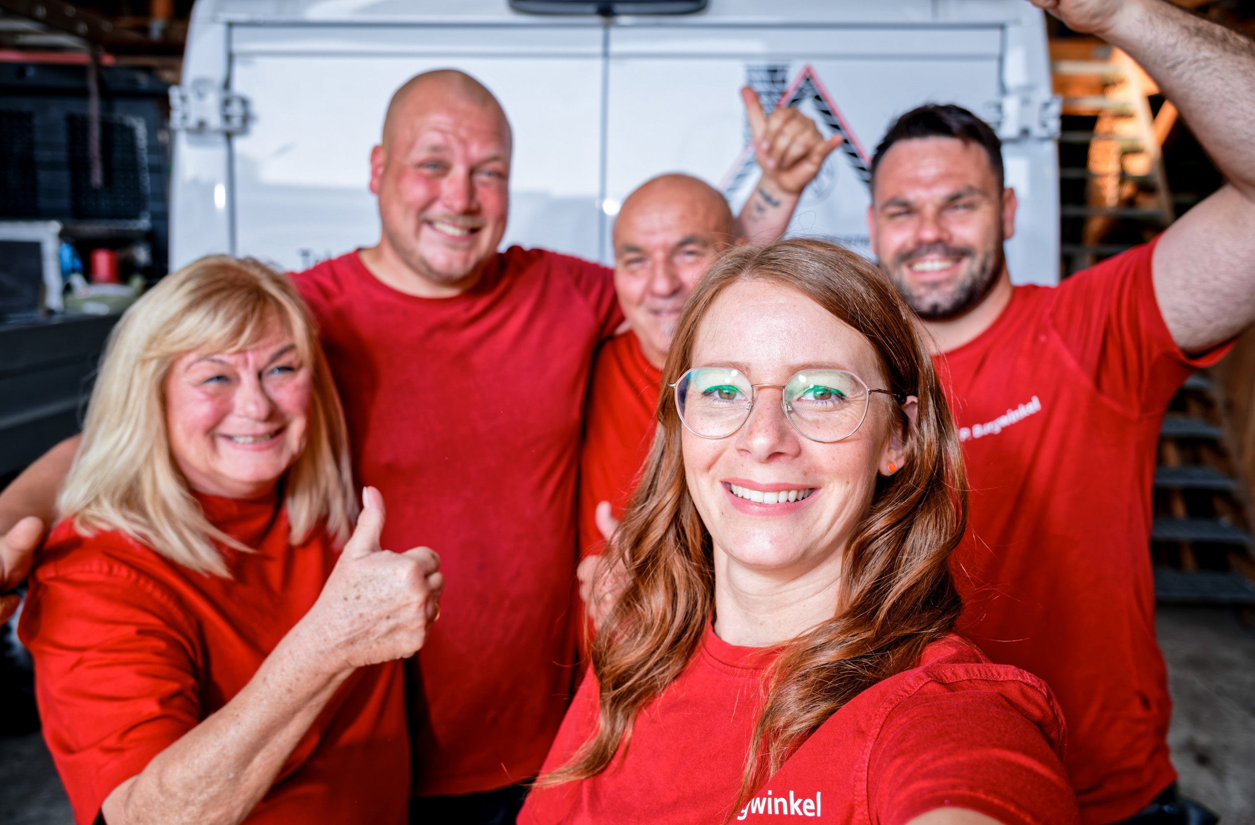 Naike, Mitarbeiterin bei Burgwinkel Bedachungen, beim Selfie mit dem Dachdecker-Team